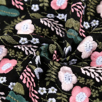 Close-up of Longon Craft’s Floral Cotton Linen Embroidered Fabric by the yard in black, featuring detailed multicolor flower embroidery on cotton linen, ideal for dressmaking and crafts.