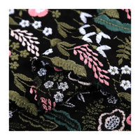 Longon Craft's Floral Cotton Linen Embroidered Fabric By the Yard features detailed green, pink, white, and blue floral embroidery on black or white cotton linen—perfect for dressmaking and creative fabric projects.