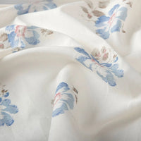 A close-up of Longan Craft Floral Digital Print Voile Fabric by the yard, a lightweight, breathable cotton with a blue, pink, and beige scattered floral pattern and gentle folds—ideal for tops.