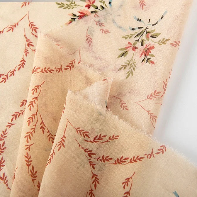 Longan Craft’s Floral Digital Print Voile Fabric by the Yard features a light beige, lightweight cotton voile with red, green, and blue floral and vine patterns. This breathable fabric is sheer, soft-textured, and ideal for tops.