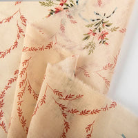 Longan Craft’s Floral Digital Print Voile Fabric by the Yard features a light beige, lightweight cotton voile with red, green, and blue floral and vine patterns. This breathable fabric is sheer, soft-textured, and ideal for tops.