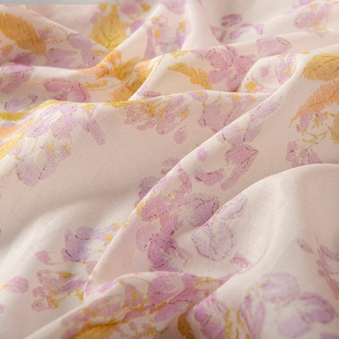 A close-up of Longan Craft's Floral Digital Print Voile Fabric by the Yard—a lightweight, breathable cotton voile with a pastel floral pattern in pink, purple, and yellow on a light background, ideal for tops.