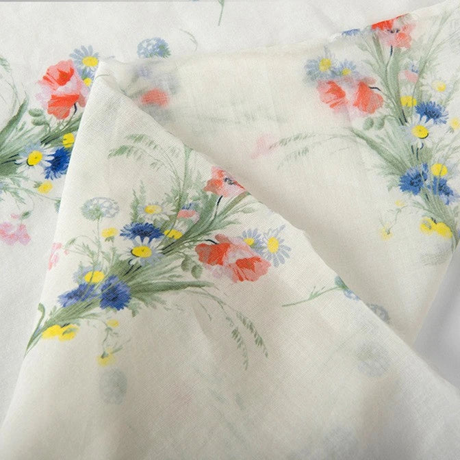 Longan Craft Floral Digital Print Voile Fabric by the yard features a lightweight, breathable cotton voile with clusters of red, blue, and yellow flowers and green leaves on soft, semi-transparent material—perfect for airy tops.