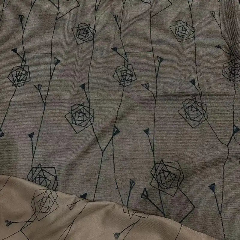 A close-up of Longan Craft’s Floral Embroidered Polyester Corduroy Fabric shows fine wale corduroy with a minimalist black geometric rose and stem design, repeated across this DIY material for pants.