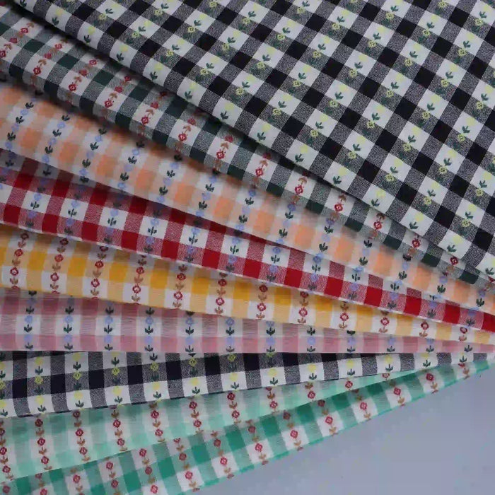 Explore the charming Floral Gingham Poplin Fabric By The Yard from Longan Craft—a collection of colorful cotton checkered jacquard poplin materials featuring gingham plaid patterns in shades of black, orange, yellow, red, and teal. Each piece is beautifully adorned with small floral designs and crafted from soft cotton fabric, making this perfect poplin fabric ideal for a range of creative garment-making and sewing projects.