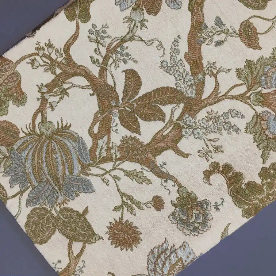 A close-up of Longan Craft's Floral Jacquard Chenille Fabric By The Yard shows brown, green, and blue botanical patterns on light beige—ideal heavyweight poly chenille upholstery fabric for elegant home decor projects.