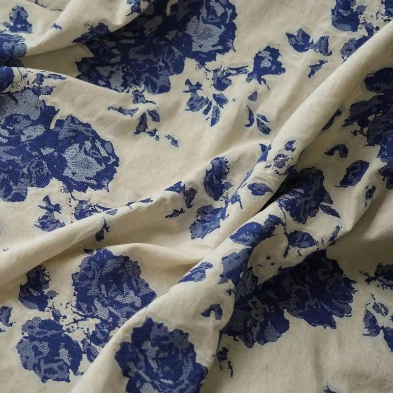 A close-up of Longan Craft's Floral Jacquard Cotton Linen Fabric By The Yard shows multicolor botanical flower prints on a soft cotton-linen blend, gently draped to display its folds—ideal DIY dressmaking material.