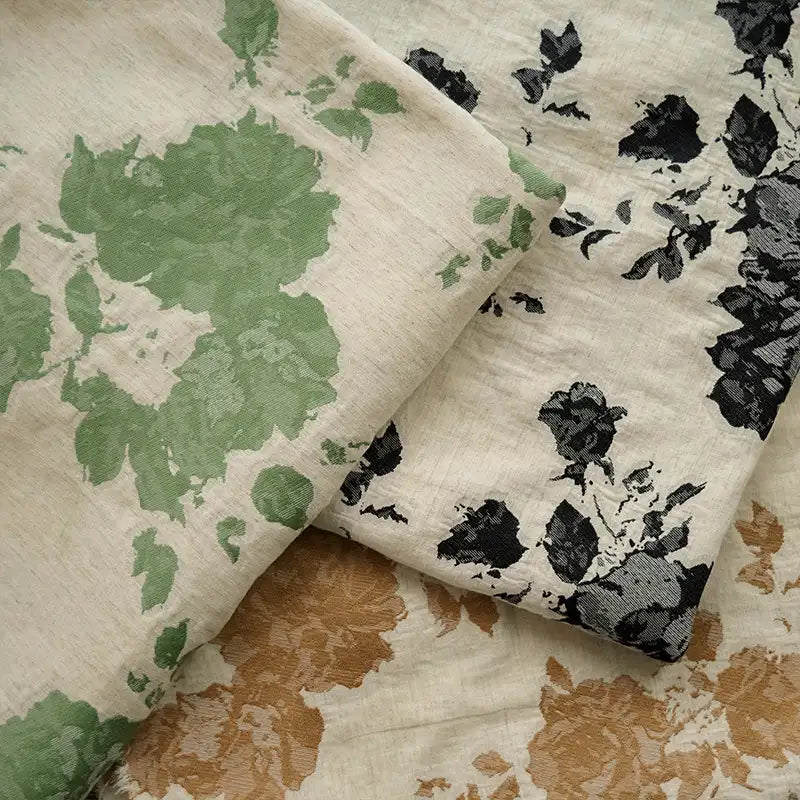 Three pieces of Longan Craft's Floral Jacquard Cotton Linen Fabric by the yard with multicolor botanical patterns—green, black, and tan on beige—slightly overlap for a charming display, perfect for DIY dressmaking.