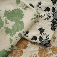 Three pieces of Longan Craft's Floral Jacquard Cotton Linen Fabric by the yard with multicolor botanical patterns—green, black, and tan on beige—slightly overlap for a charming display, perfect for DIY dressmaking.