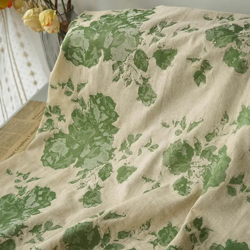 The Longan Craft Floral Jacquard Cotton Linen Fabric features large green and yellow botanical prints on a beige background, perfect for dressmaking. Sold by the yard. Sheer curtain shown for styling inspiration.
