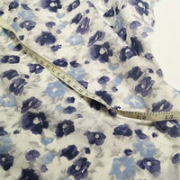 The Longan Craft Floral Print Chiffon Silk Fabric By The Yard, a lightweight cotton silk with blue and purple florals, is spread flat with a measuring tape in inches—ideal for creating elegant sheer curtains or beautiful clothing.