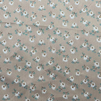 Longan Craft's Floral Printed Peachskin Fabric by the yard features a beige microfiber polyester base with a small white floral pattern, green leaves, and brown flower centers scattered across its comfy peachskin texture—perfect for apparel.