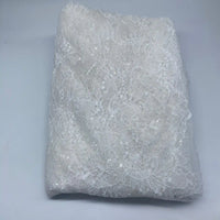 Longan Craft's Floral Sequin Lace Fabric By The Yard features a delicate floral pattern with colorful, sparkling sequins—ideal for dresses or bridal wear. Shown folded on a light gray surface.