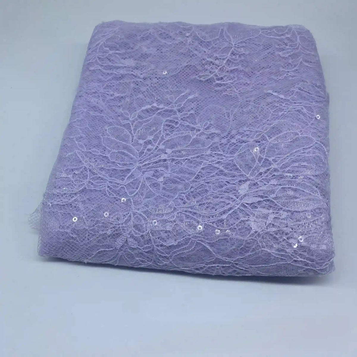 A piece of Floral Sequin Lace Fabric By The Yard from Longan Craft, featuring colorful sparkling lace and floral patterns for dresses, is displayed folded on a plain white surface.