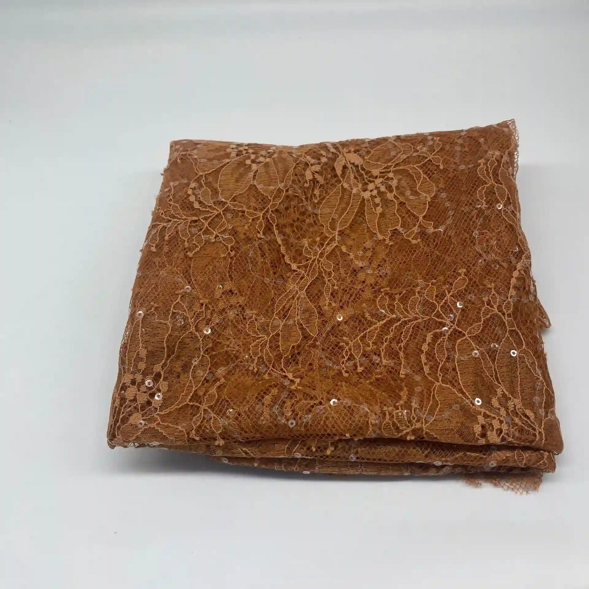 A folded piece of Longan Craft Floral Sequin Lace Fabric By The Yard—colorful sparkling lace with a delicate floral pattern—ideal for dresses, displayed on a plain white surface.