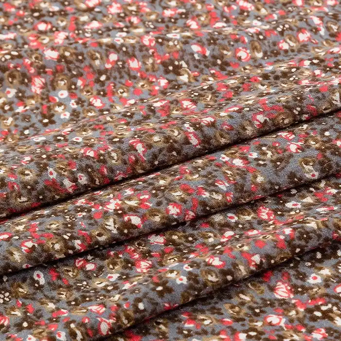 A close-up of Longan Craft's Floral and Animal Printed Jersey Fabric By The Yard, made from soft 100% cotton jersey, shows breathable fabric with small brown, red, and white floral patterns on a gray background. Ideal for dresses and clothing.