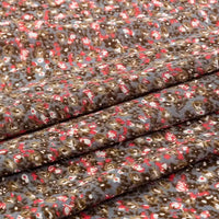 A close-up of Longan Craft's Floral and Animal Printed Jersey Fabric By The Yard, made from soft 100% cotton jersey, shows breathable fabric with small brown, red, and white floral patterns on a gray background. Ideal for dresses and clothing.