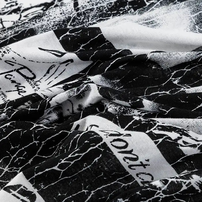 A close-up of Longan Craft’s Floral and Animal Printed 100% Cotton Jersey Fabric, featuring abstract illustrations and partial handwritten text on a slightly wrinkled black and white material—perfect for dresses or jersey clothing.