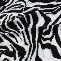 Close-up of Longan Craft’s Floral and Animal Printed 100% Cotton Jersey Fabric by the yard, featuring bold black and white zebra stripes with a soft, velvety texture—ideal jersey material for dresses and clothing.