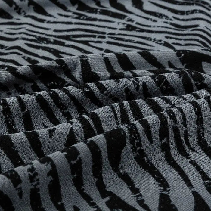 Close-up of Longan Craft 100% cotton jersey fabric by the yard, featuring a floral and animal print with soft folds and a breathable, slightly textured surface—ideal jersey material for dresses.