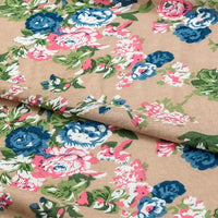 A close-up of Longan Craft's Floral and Animal Printed Jersey Fabric (100% cotton) displays its blue, pink, and white floral pattern with green leaves. This beige jersey fabric is ideal for dresses and sold by the yard.