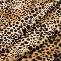 Close-up of Longan Craft Floral and Animal Printed Jersey Fabric, made of 100% cotton. This soft jersey material by the yard features a leopard print in brown, black, and beige—ideal for dresses and clothing projects.