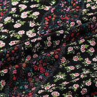 Close-up of Longan Craft’s Floral and Animal Printed Jersey Fabric by the yard, made from 100% cotton. The fabric features colorful floral patterns with red, white, and pink flowers plus green leaves, showcasing its soft texture and depth.