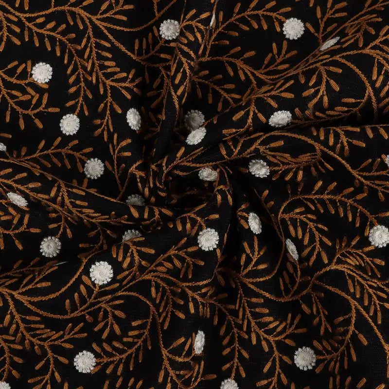 The Flower Embroidered Linen Fabric By The Yard from Longan craft features black linen with elegant floral embroidery, white dots, and brown leafy branches. This breathable sewing fabric is ideal for dresses and ensures comfort with stylish detail.