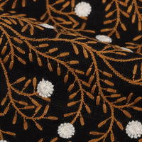 Close-up of Flower Embroidered Linen Fabric By The Yard by Longan craft, featuring black linen with golden-brown leafy branches and white floral embroidery, ideal for sewing dresses.