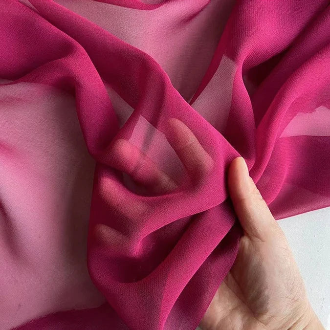 A hand showcases the lightweight, translucent texture of Longan Craft's Georgette Silk Fabric By The Yard—8 Momme Pure Mulberry Silk Crepe, perfect as a soft silk drapery fabric.
