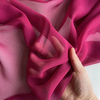 A hand showcases the lightweight, translucent texture of Longan Craft's Georgette Silk Fabric By The Yard—8 Momme Pure Mulberry Silk Crepe, perfect as a soft silk drapery fabric.