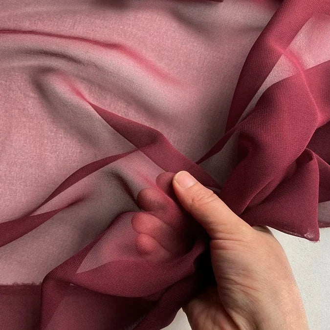 A hand displays Longan Craft's Georgette Silk Fabric By The Yard (8 Momme Pure Mulberry Silk Crepe), showing its sheer and delicate texture against a light background.