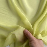 A hand gently gathers the sheer, delicate Georgette Silk Fabric by Longan Craft—8 Momme pure Mulberry silk crepe fabric, available by the yard—highlighting its soft, translucent texture.