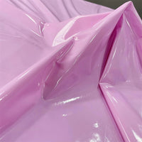 A close-up of Longan Craft's glossy stretch vinyl fabric by the yard, a shiny solid color PU material with mirror-like folds and reflections—perfect for making jackets.