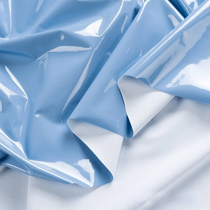 Longan Craft’s Glossy Stretch Vinyl Fabric by the Yard features a shiny light blue and white PU surface with soft folds and highlights—perfect for making jackets and other creative projects.
