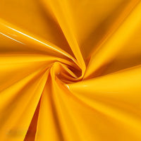Longan Craft's Glossy Stretch Vinyl Fabric by the yard shines with a bright yellow, mirror-finish surface twisted into a spiral, highlighting its smooth, solid-color PU vinyl—ideal for making jackets.