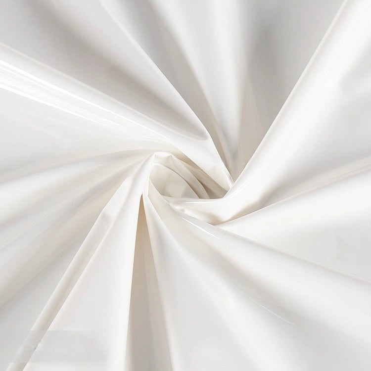 Close-up of Longan Craft’s Glossy Stretch Vinyl Fabric By The Yard, a solid color shiny PU vinyl perfect for jackets. Gentle folds swirl from the center, as light reflects off its smooth mirror finish.