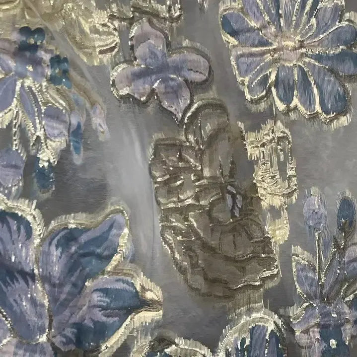 Close-up of Longan Craft’s Golden Floral Jacquard Organza Fabric by the yard, showcasing purple flower patterns and intricate gold embroidery on a sheer, translucent organza—perfect organza material for dressmaking.