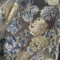 A close-up of Golden Floral Jacquard Organza Fabric by the yard from Longan Craft, featuring sheer organza material with metallic gold and purple flower patterns—perfect for dressmaking.