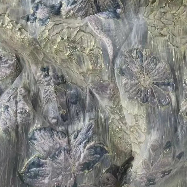 Close-up of Golden Floral Jacquard Organza Fabric by Longan Craft, showcasing a textured purple flower pattern with shimmering accents—perfect organza material for dressmaking, sold by the yard.