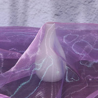 A white vase is partially draped with Longan Craft's Gradient Organza Fabric By The Yard, a lightweight ombre organza material, set against a light textured background.