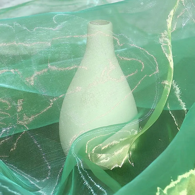 A white vase-shaped object is draped with Longan Craft’s Gradient Organza Fabric By The Yard, a lightweight ombre organza with shiny threads, lending a soft and dreamy look reminiscent of elegant bridal gowns.