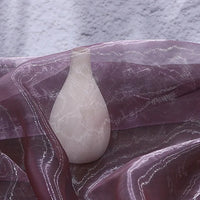 A white vase is draped with Longan Craft’s Gradient Organza Fabric By The Yard, a lightweight ombre organza cloth, set against a textured light gray background.