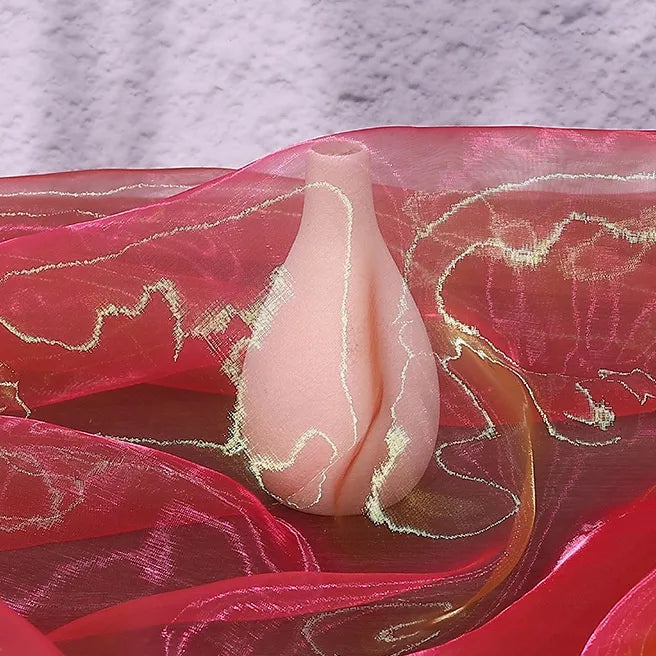 A pale pink, pear-shaped vase rests on Longan Craft's Gradient Organza Fabric By The Yard in sheer red and gold tones, set against a textured light purple background.