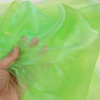 A hand displays Longan Craft's Gradient Organza Fabric By The Yard, showing off the soft, lightweight ombre organza cloth’s translucent neon green texture.