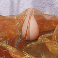 A pear-shaped object partially draped with Longan Craft’s Gradient Organza Fabric By The Yard, a lightweight ombre organza, is set against a lightly textured background.