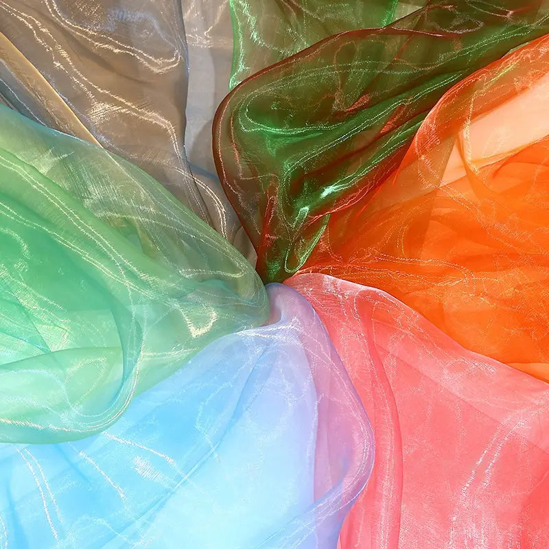 Longan Craft’s Gradient Organza Fabric By The Yard features lightweight ombre organza in green, blue, orange, beige, and pink with a soft shimmer—ideal for bridal gowns or sheer fabric projects.