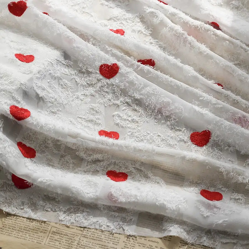 Longan craft’s Heart Embroidered Tassel Chiffon Fabric features sheer white jacquard chiffon, red heart embroidery, and a fuzzy texture, making it ideal for sewing spring and summer women's dresses.
