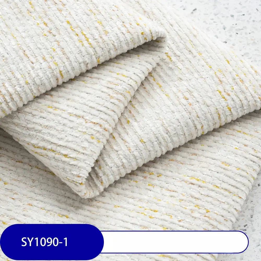 Close-up of Heavy Weight Slub Chenille Fabric by Longan Craft, showing cream-colored, textured chenille with yellow flecks and horizontal ridges. Label reads SY1090-1—perfect thick polyester for premium upholstery projects.