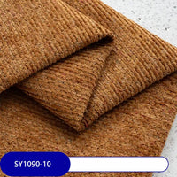 Folded pieces of textured brown Heavy Weight Slub Chenille Fabric by Longan Craft are stacked on a speckled surface. A blue and white label reads SY1090-10. This thick premium polyester fabric adds depth and style to any décor.